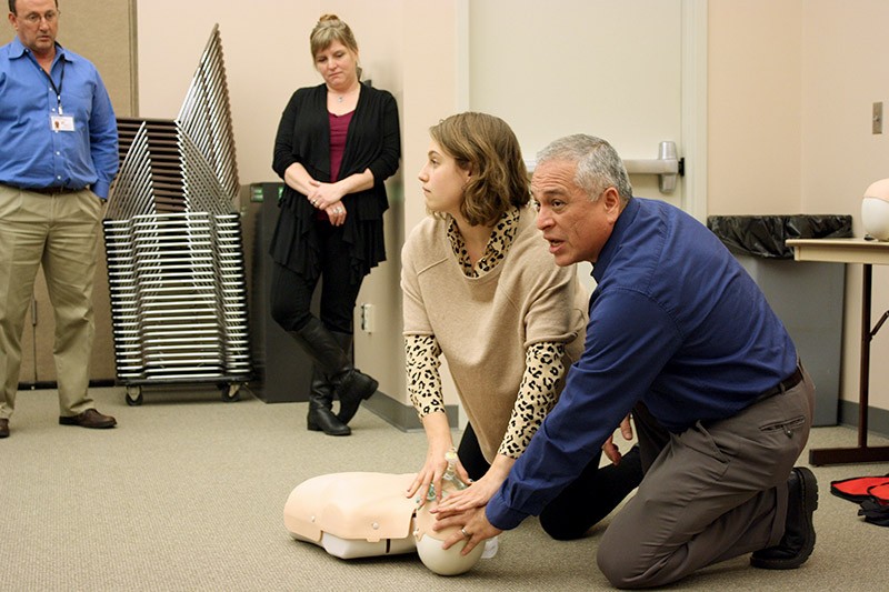 Megan Streeter and Milt Villegas demonstrate how to perform CPR on a dummy.