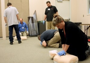 Staff practicing CPR techniques on dummies.