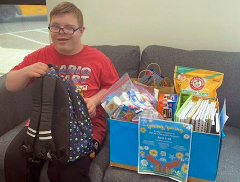 SpringGiving2 A student posing with collected supplies