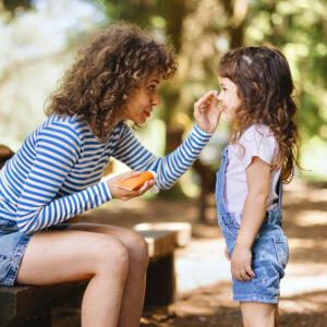 Mom applying sunscreen to daughter